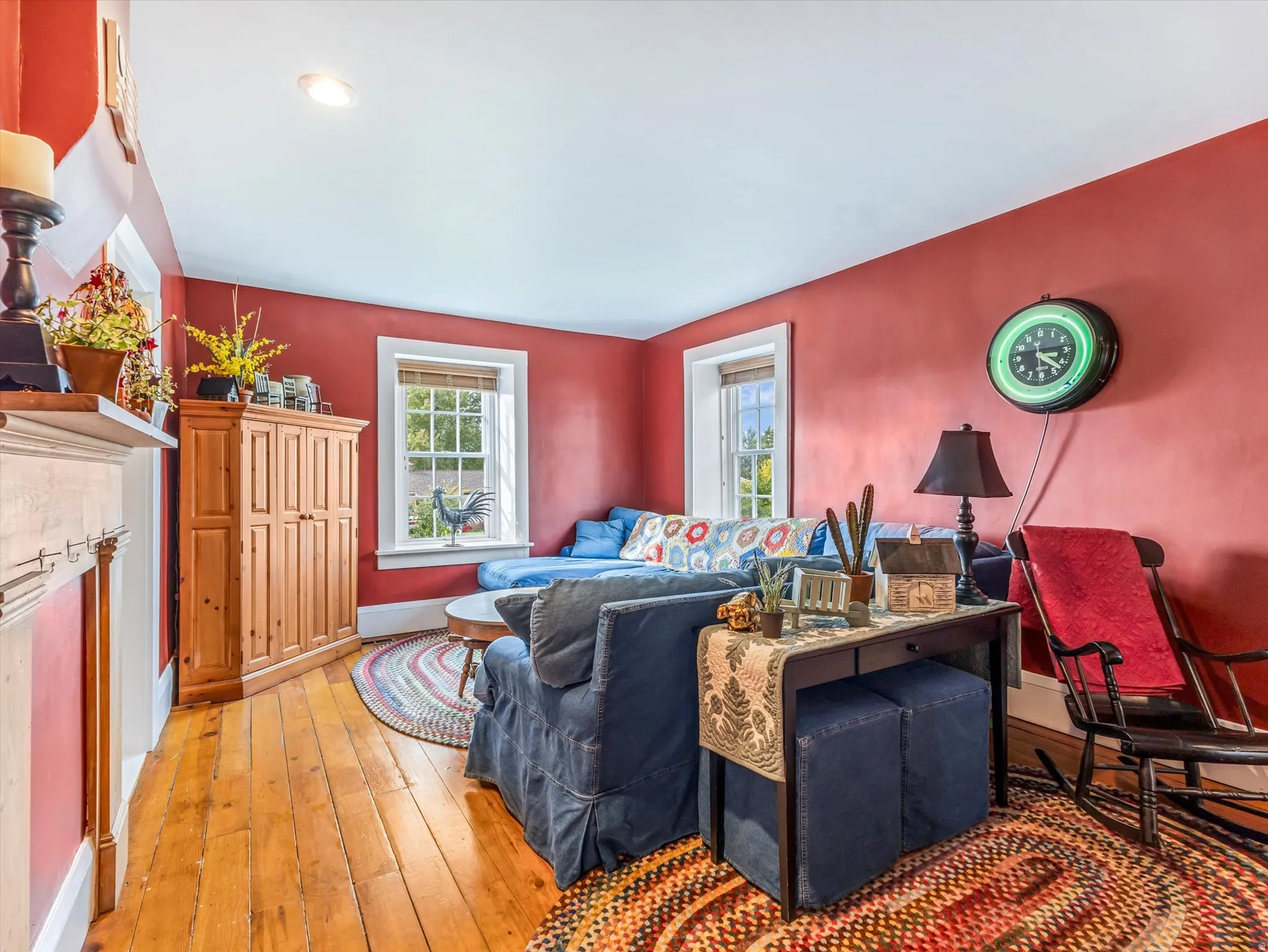 Living area featuring red painted walls, hardwood flooring, recessed lighting, and white trim windows