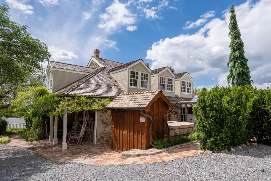 South Side Stone and siding exterior with multiple dormer windows, a wood shake roof, and a brick patio
