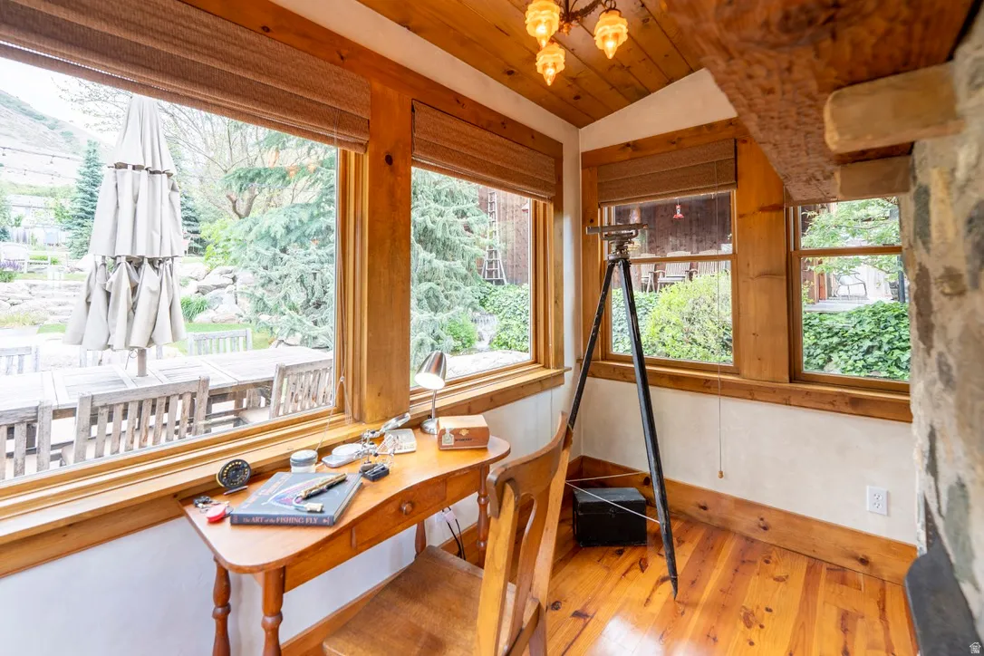 Wood-paneled ceiling with an exposed beam and a multi-light fixture