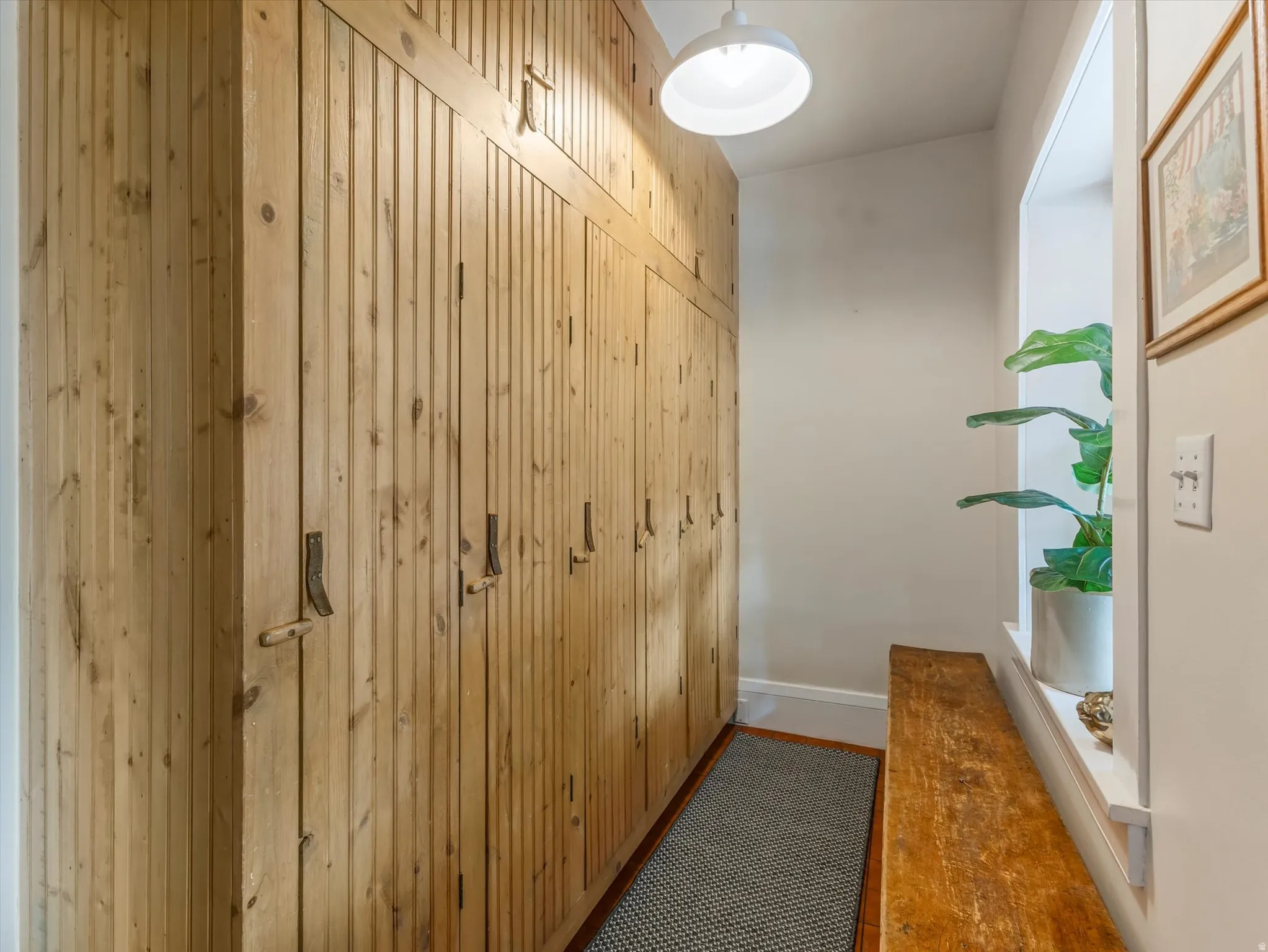 Natural wood-finish built-in cabinetry with vertical paneling and rustic hardware