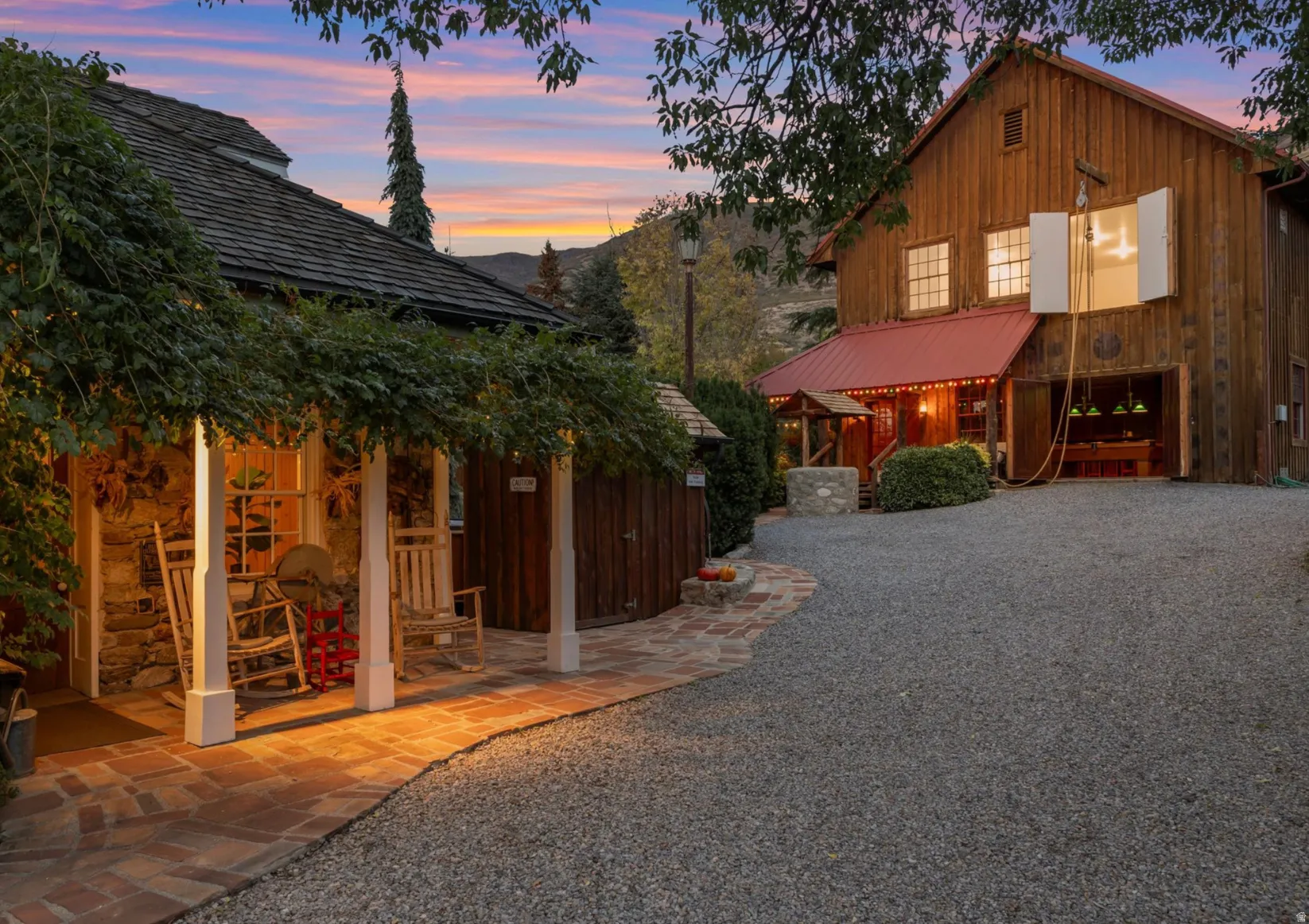 Stone-clad structure with vine-covered porch and brick pathway