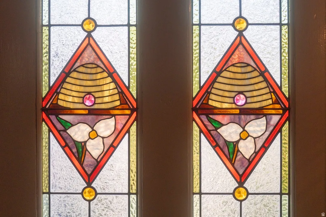 Stained glass window panels featuring beehive and trillium flower motifs
