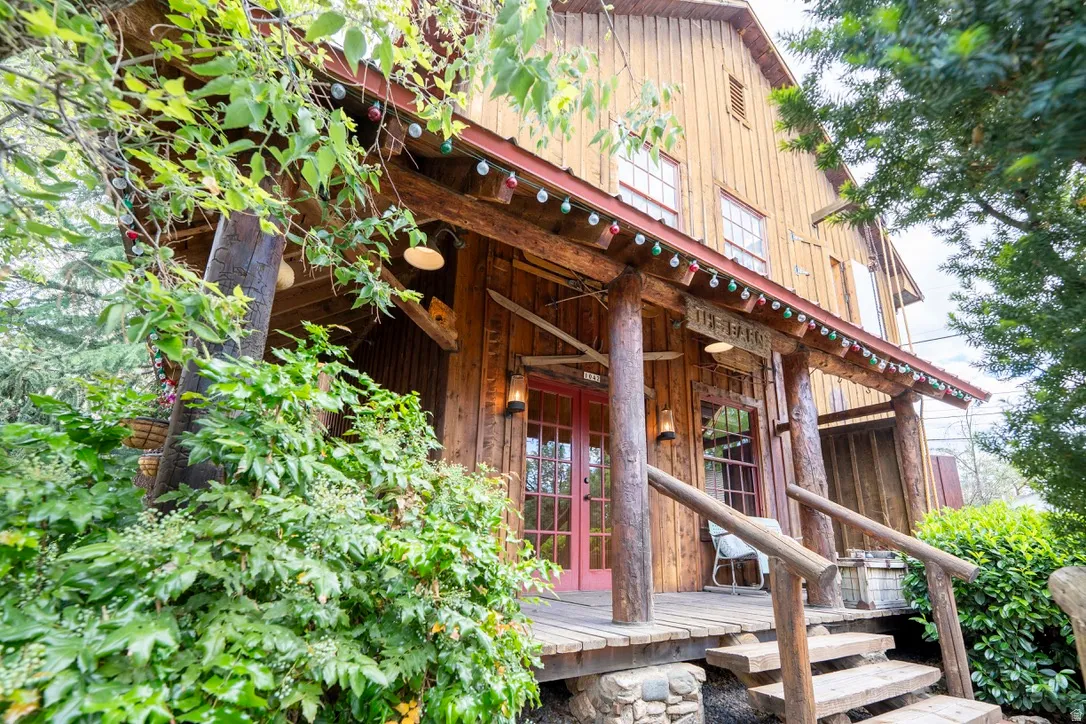 Wood-sided exterior featuring a covered porch with log supports and railings