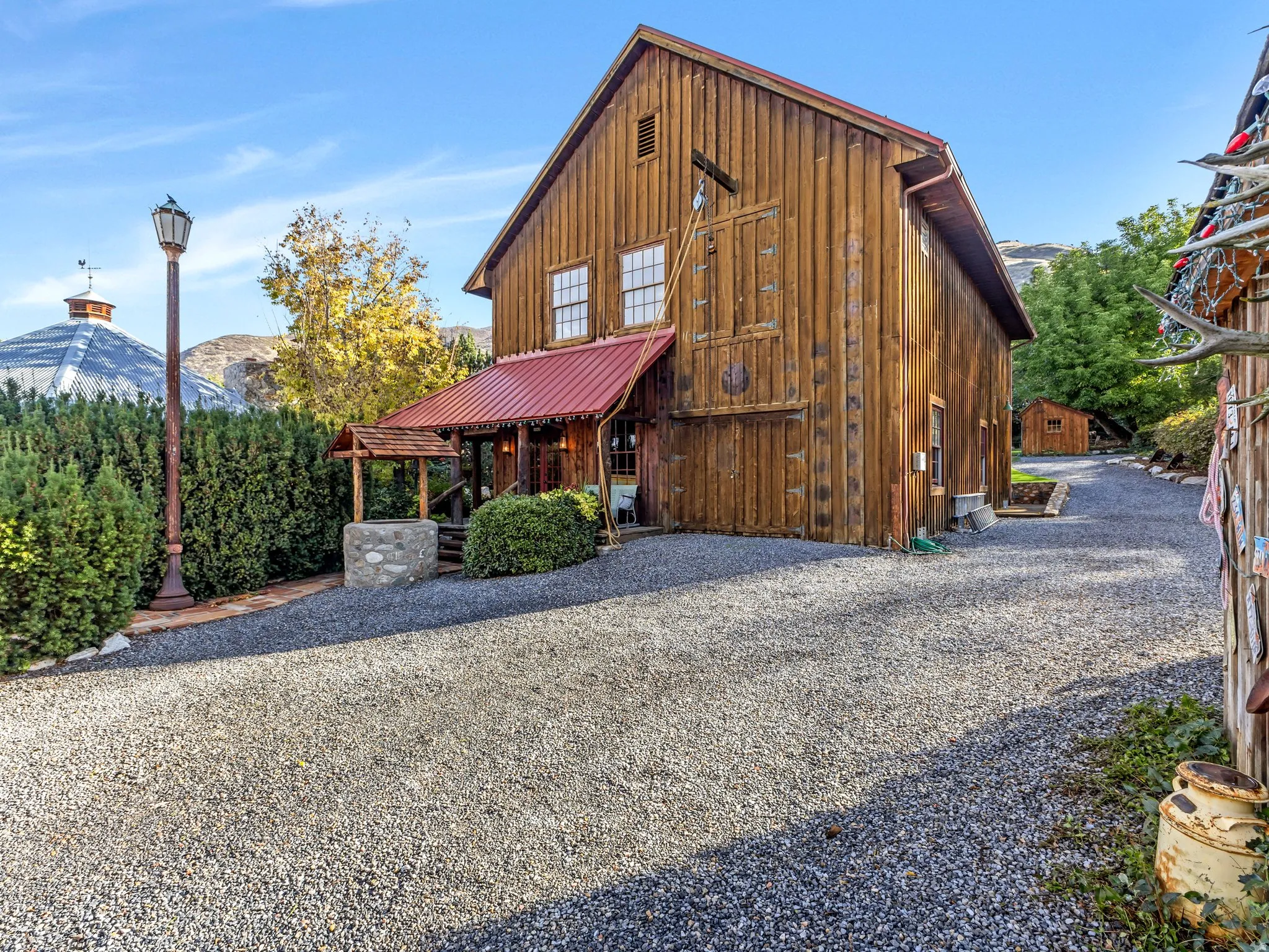 Wood-sided ADU with a red metal roof and multiple windows