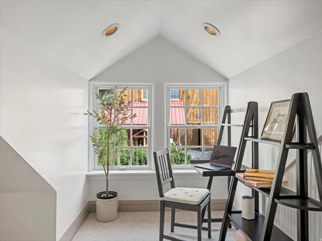 Attic space featuring a gabled ceiling, two double-hung windows, recessed lighting, and carpeted flooring