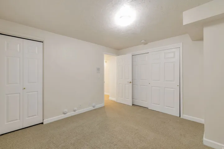 Spacious room featuring neutral carpet flooring and white painted walls
