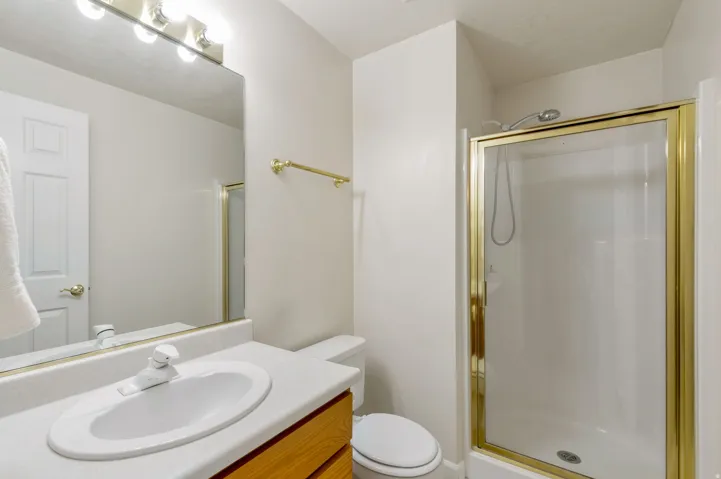 Bathroom featuring an integrated vanity sink with a laminate countertop and wood-finish cabinetry