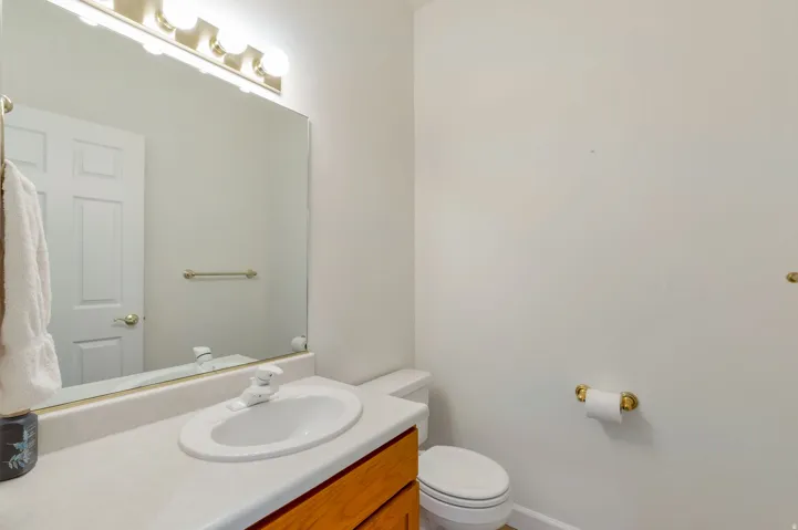 Bathroom vanity featuring a single basin sink, laminate countertop, and wood-finish cabinetry