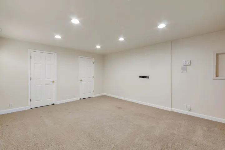 Spacious room featuring neutral carpeting and recessed lighting