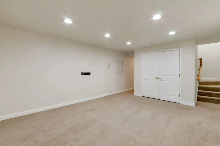 Carpeted room with recessed lighting and light-colored walls