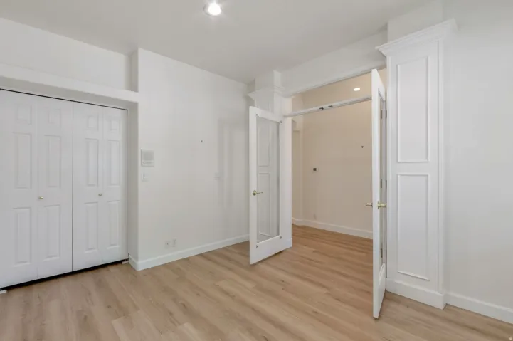 Bright room featuring wood-finish flooring, recessed ceiling lighting, and crisp white walls