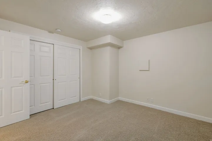 Neutral-toned walls and plush carpeting complement the white trim and six-panel doors