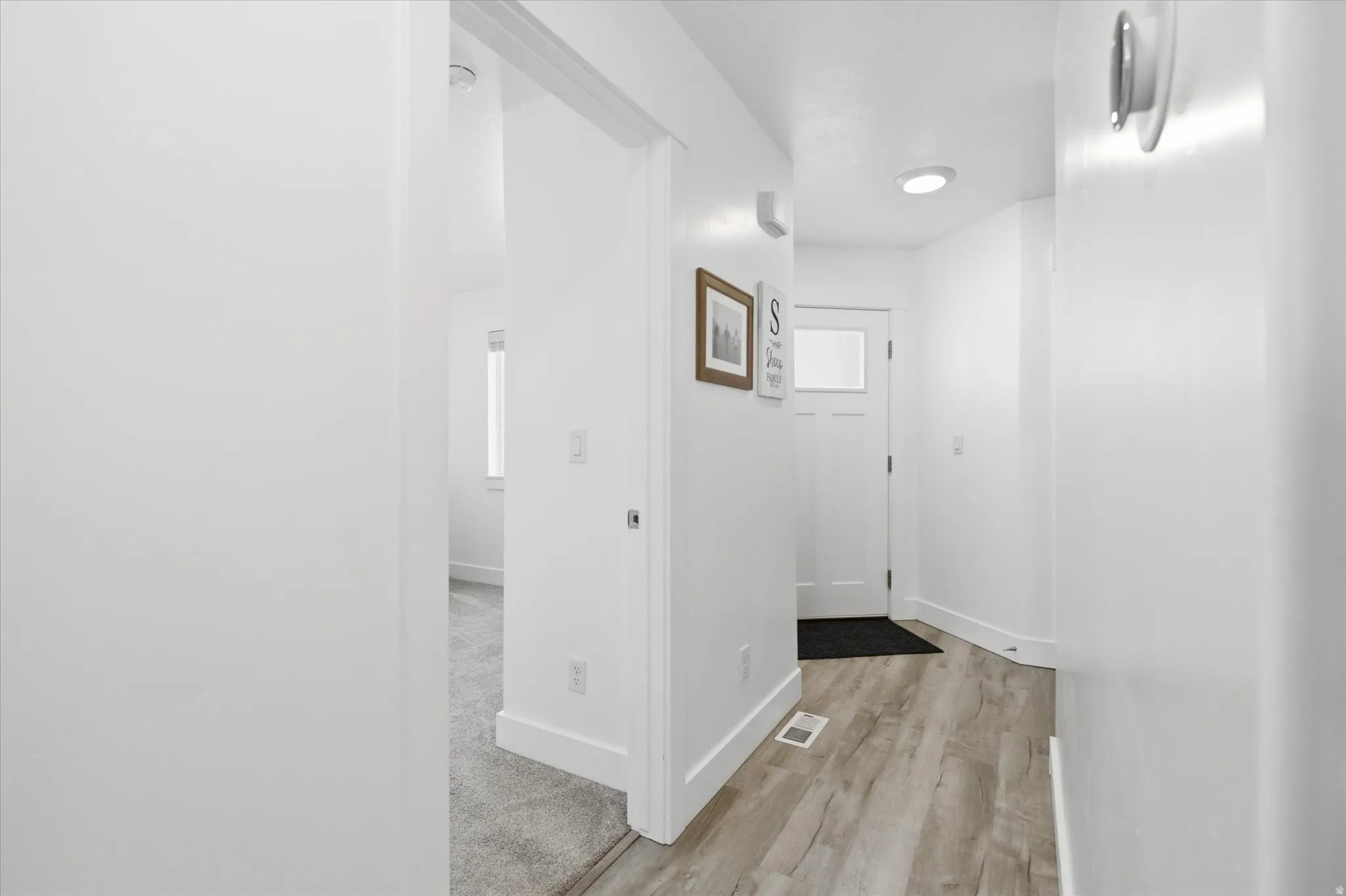 Entryway featuring wood-finish flooring, recessed lighting, and a white paneled door with a glass insert