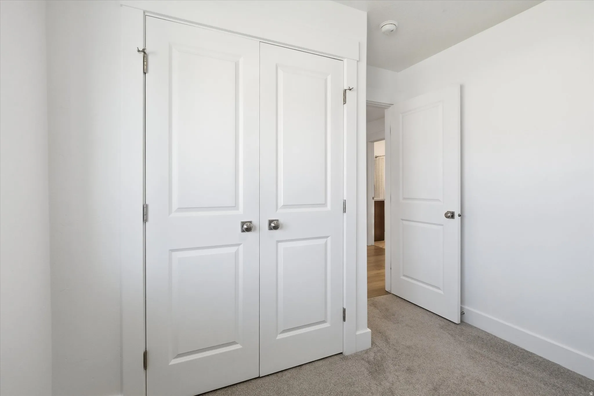 Interior space with white walls and light-colored carpeting