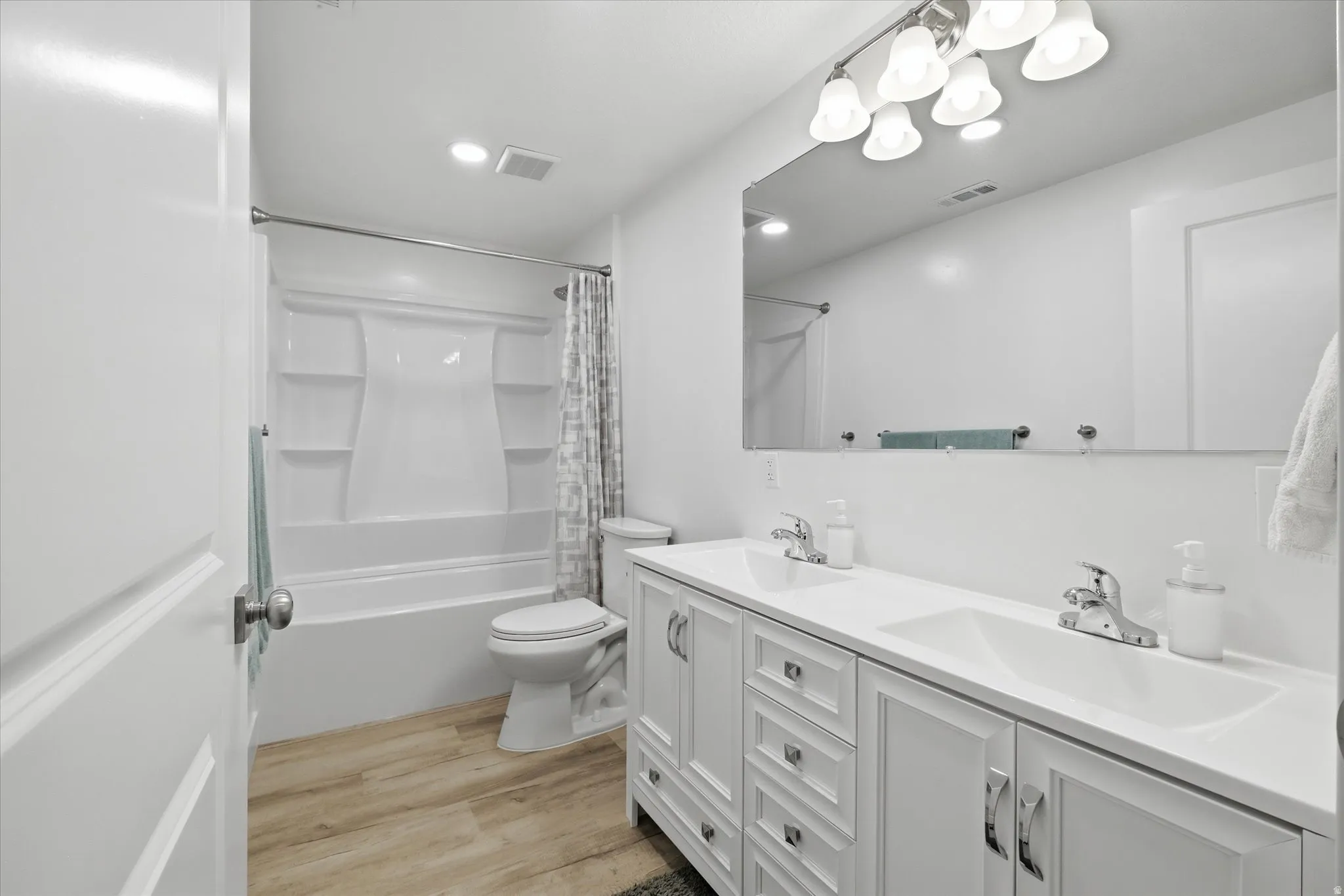 Double vanity with integrated sinks, chrome fixtures, and white cabinetry