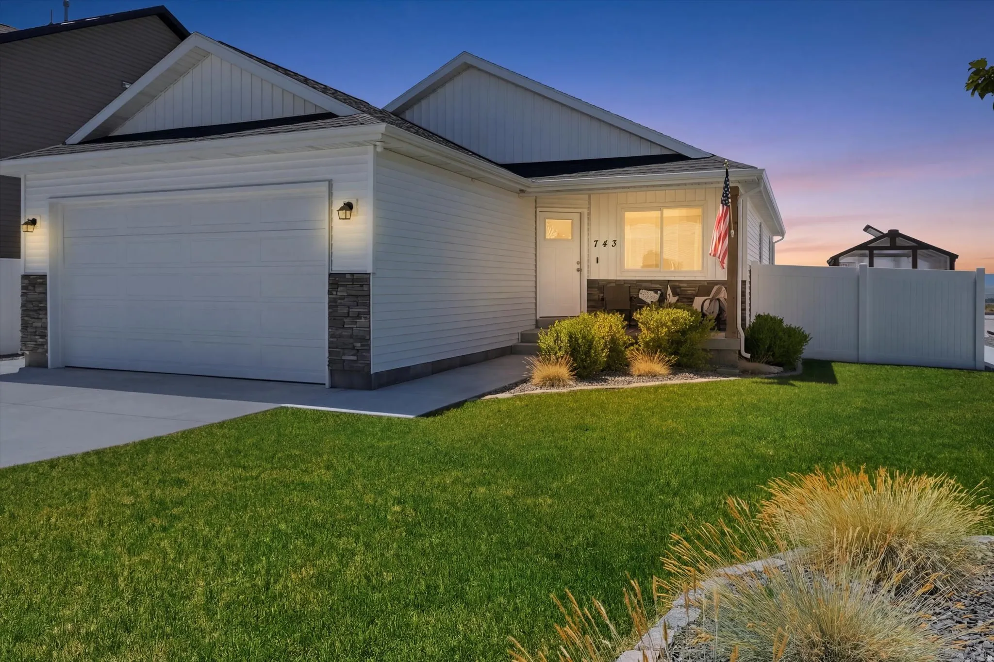 Residence featuring white siding and stone veneer accents