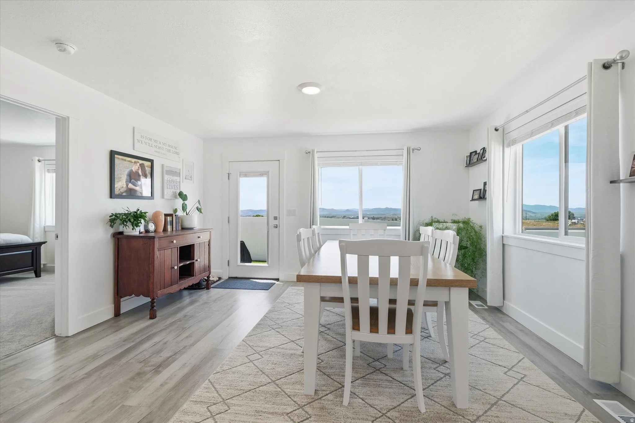Bright dining space featuring wood-finish flooring and white walls
