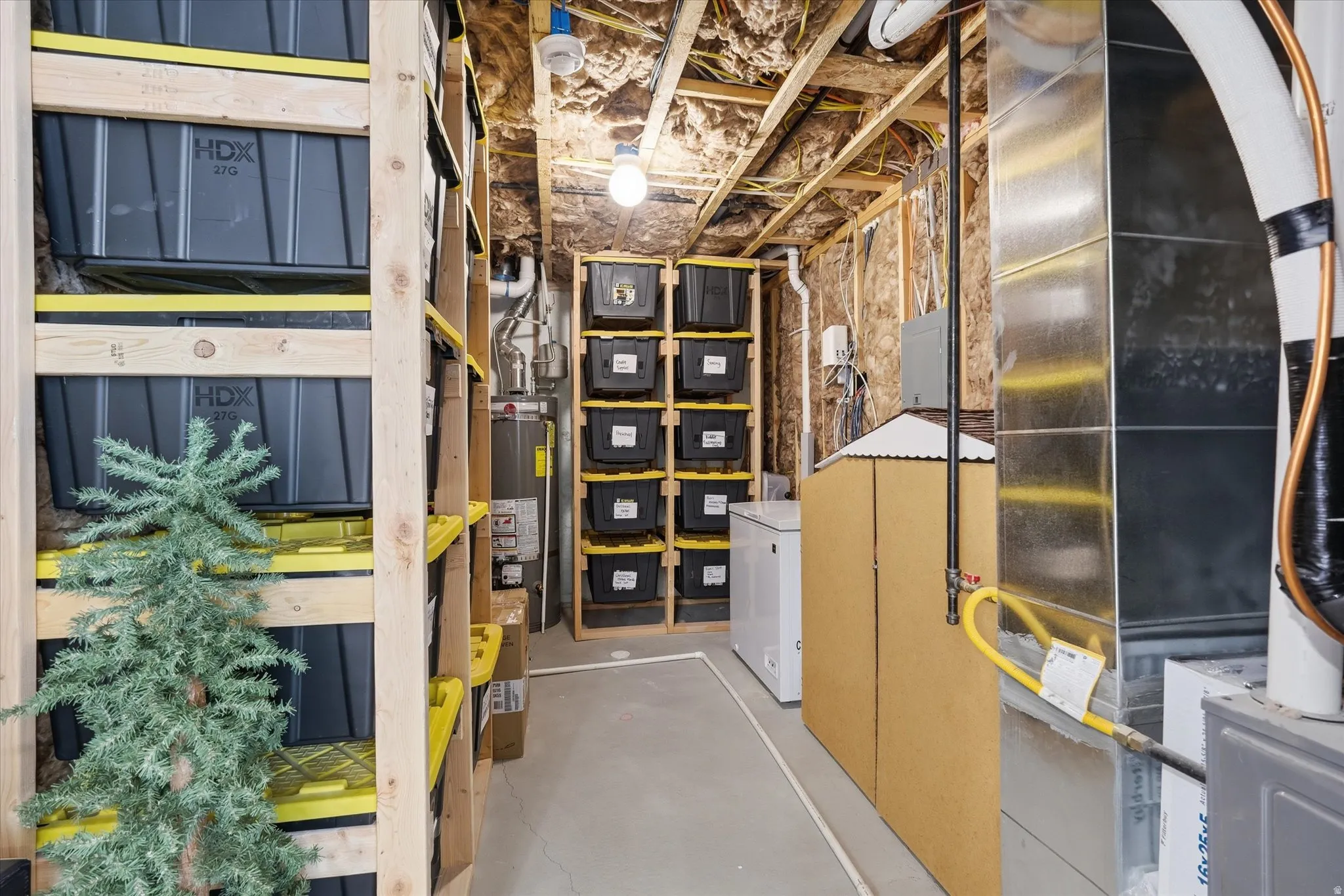 Unfinished basement utility area featuring exposed joists, insulation, and concrete flooring