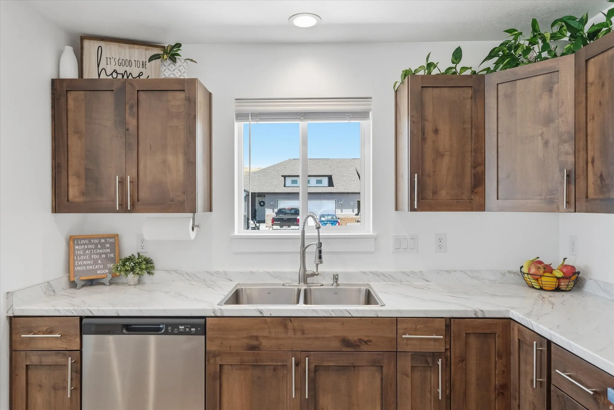 Kitchen featuring a dual-basin stainless steel sink, a modern pull-down faucet, and a stainless steel dishwasher