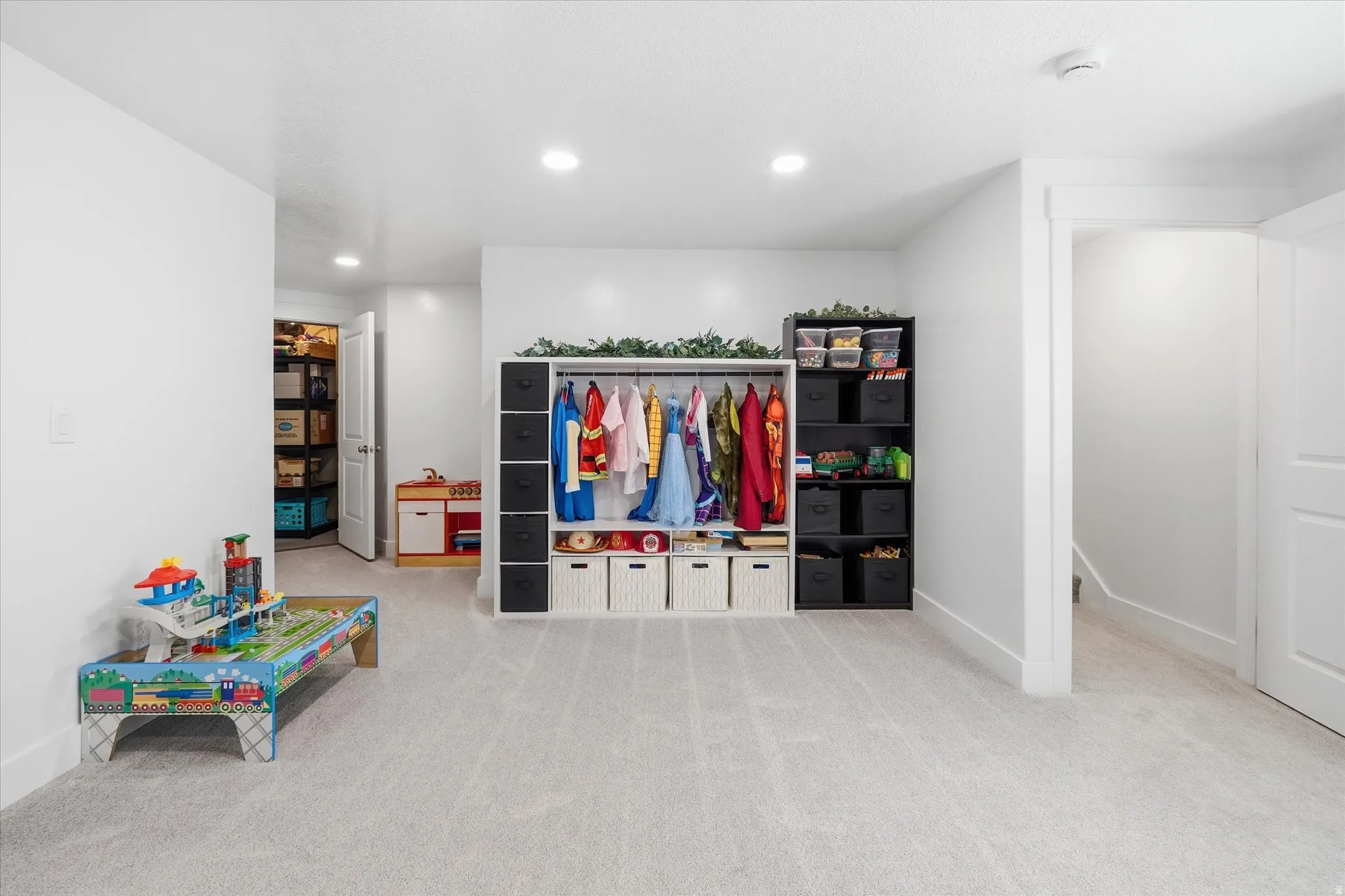 Spacious room featuring light-toned carpeting and neutral wall finishes