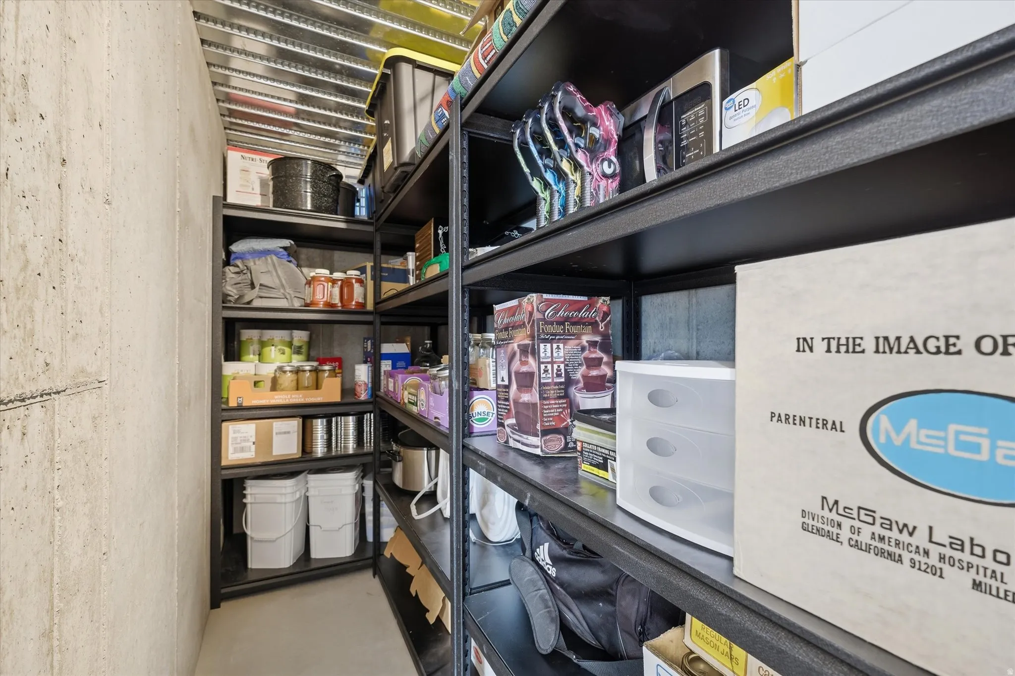 Dedicated storage area featuring concrete walls and metal shelving units, offering extensive organizational capacity