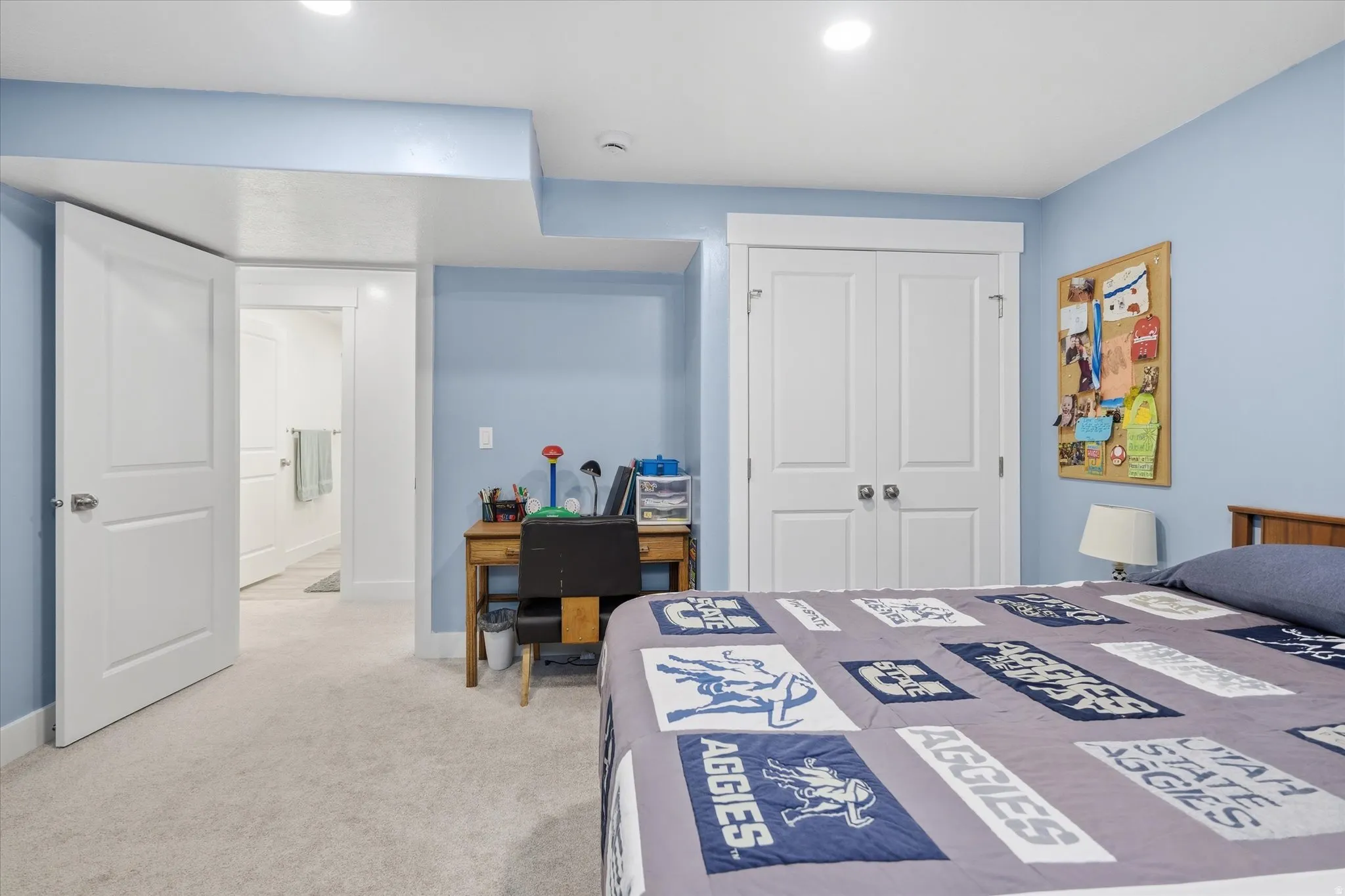 Bedroom featuring light blue walls, soft carpet flooring, and white trim