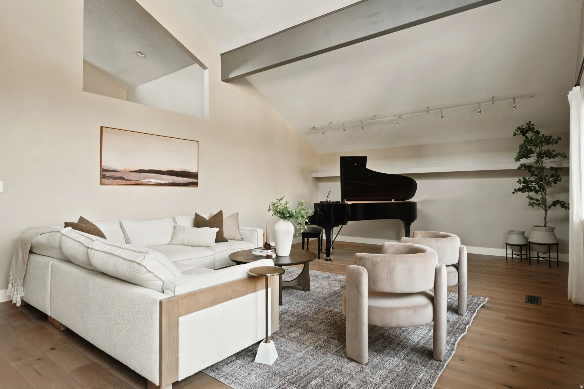 Vaulted ceiling with exposed beam, wood-finish flooring, recessed lighting, and track lighting fixtures