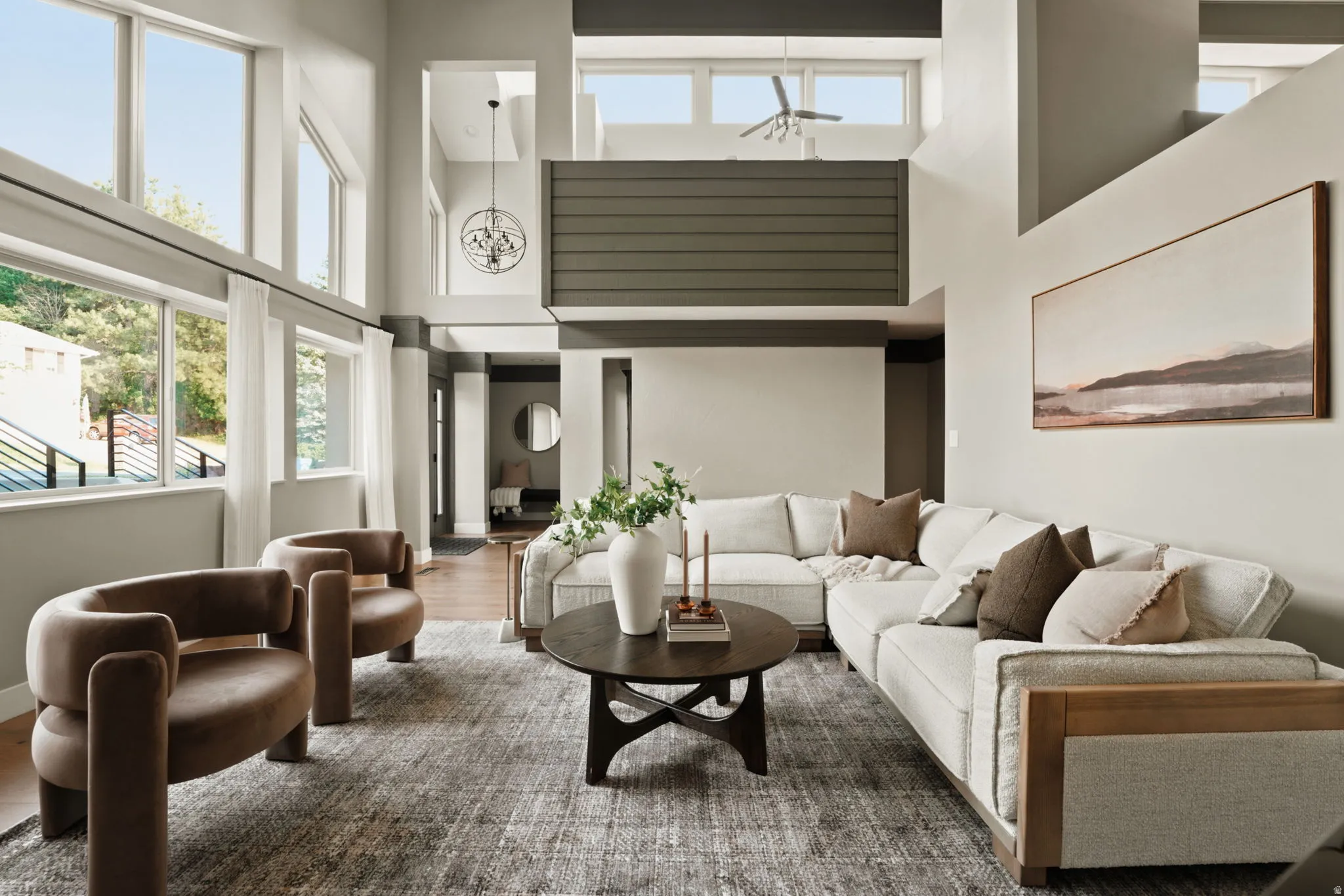 Living area featuring high ceilings, extensive window banks, and wood-finish flooring