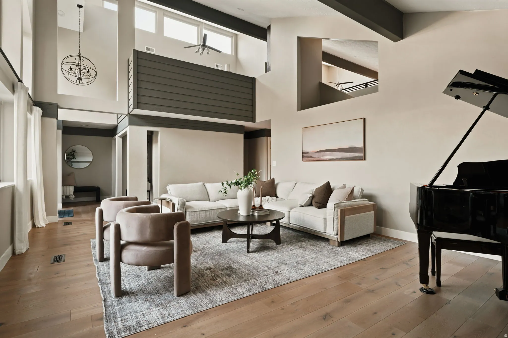 Two-story living area featuring wood-finish flooring, a vaulted ceiling, and an open loft overlook