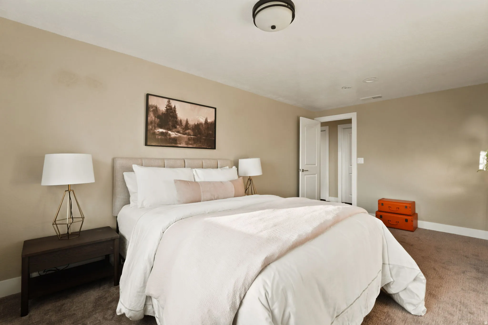 Bedroom featuring a light-colored upholstered headboard, neutral wall paint, and gray carpet flooring