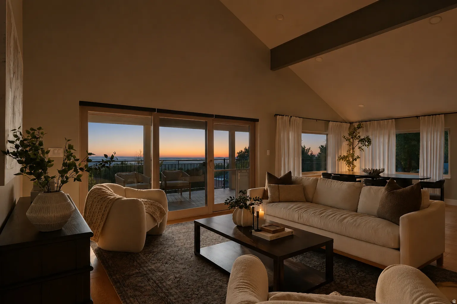 Vaulted ceiling living area with a large slider door opening to a private deck and a broad expanse of sky