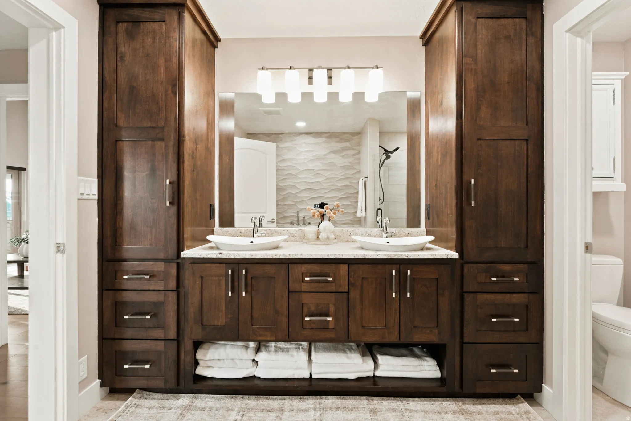 Bathroom featuring a double vanity with stone countertops and vessel sinks