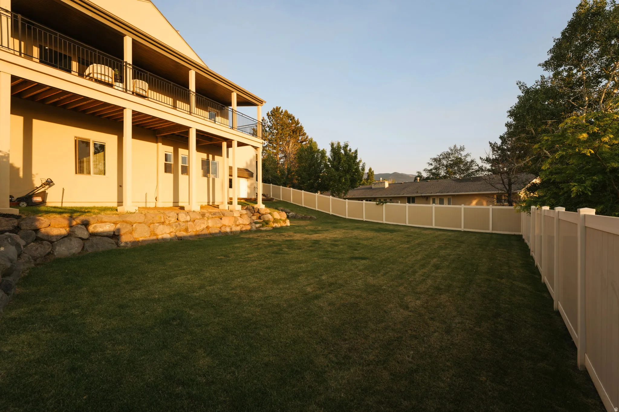 Expansive green lawn with a full privacy fence