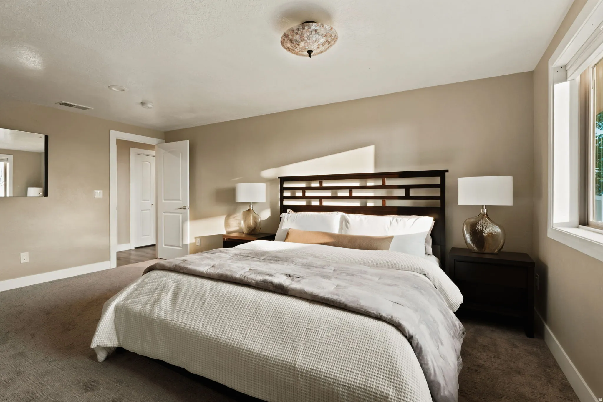 Spacious room featuring neutral-toned walls, recessed lighting, and a large window providing natural illumination