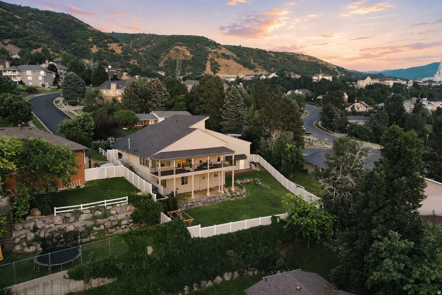Two-story residence featuring a covered upper-level balcony and a lower-level patio with columnar supports