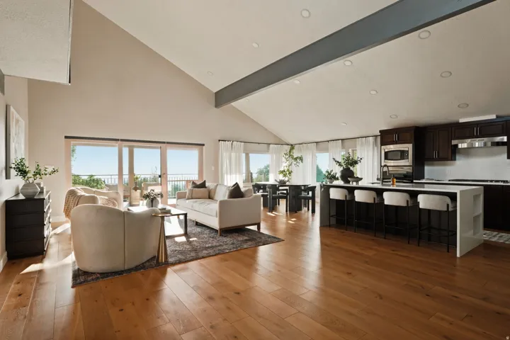 Open-concept living area with vaulted ceilings and wood-finish flooring