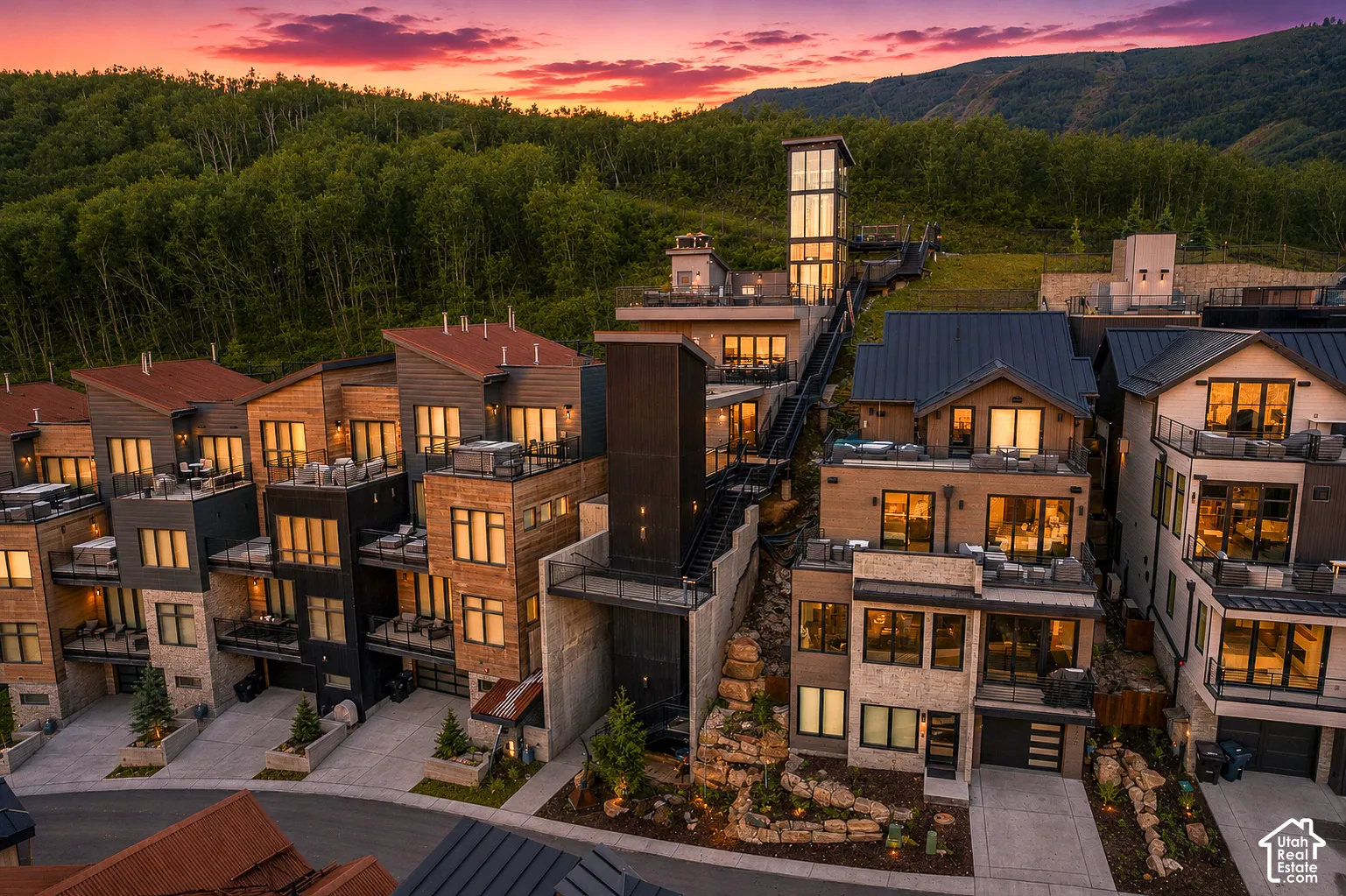 Modern multi-level residences featuring varied rooflines, extensive window placements, and private balcony spaces