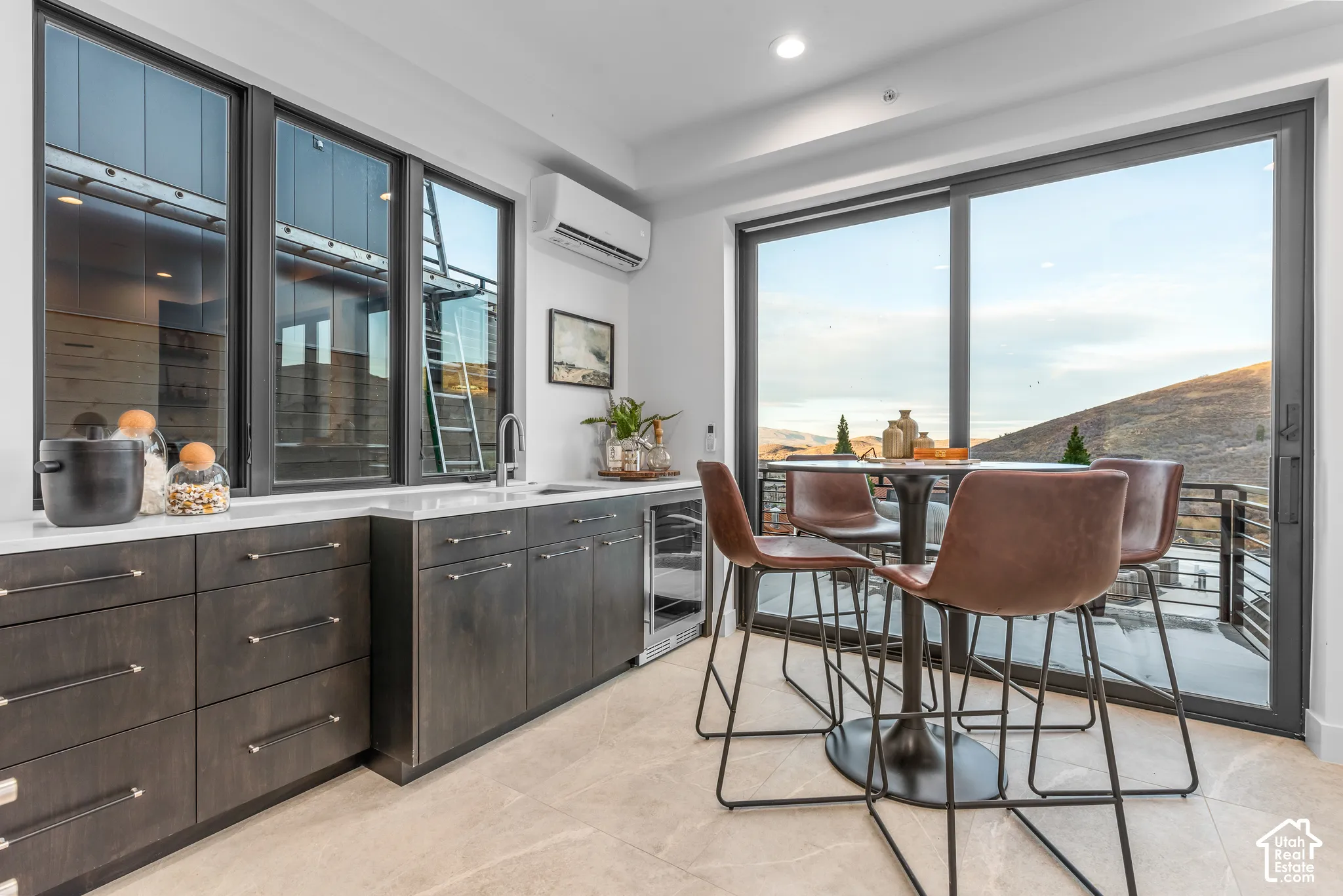 Wet bar featuring dark wood-finish cabinetry, a white countertop, a built-in beverage refrigerator, and a stainless steel sink with a gooseneck faucet