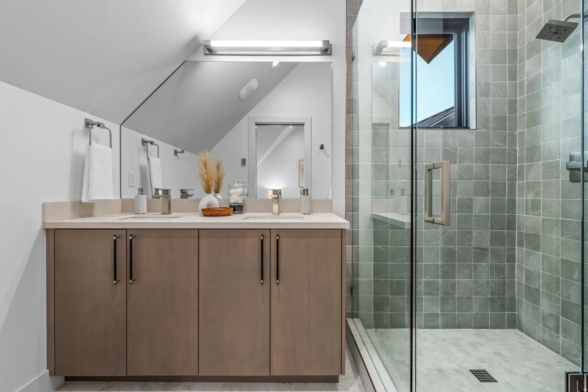 Bathroom featuring a dual-sink vanity with light-toned cabinetry and a light countertop