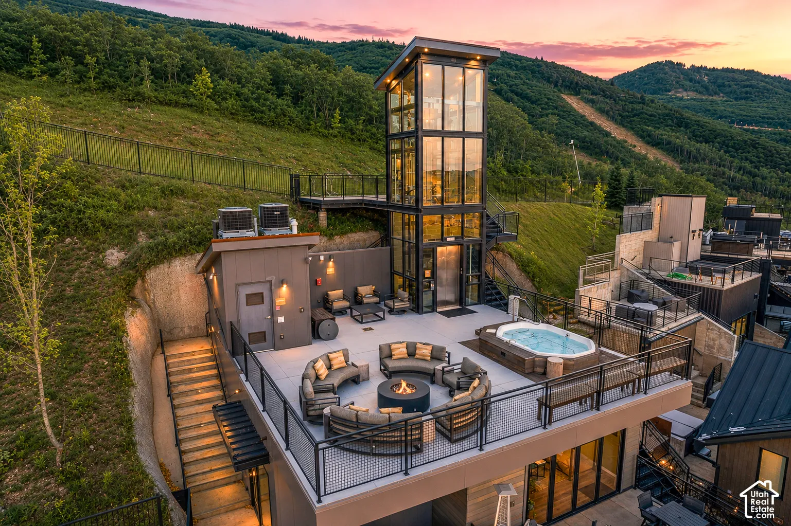 Expansive rooftop deck featuring a built-in hot tub, fire pit, and ample lounge seating