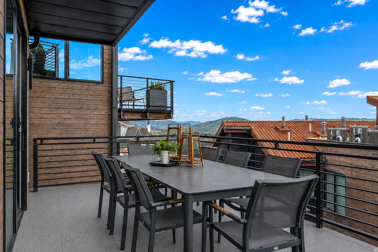 Outdoor terrace featuring a concrete-style floor and black metal railings