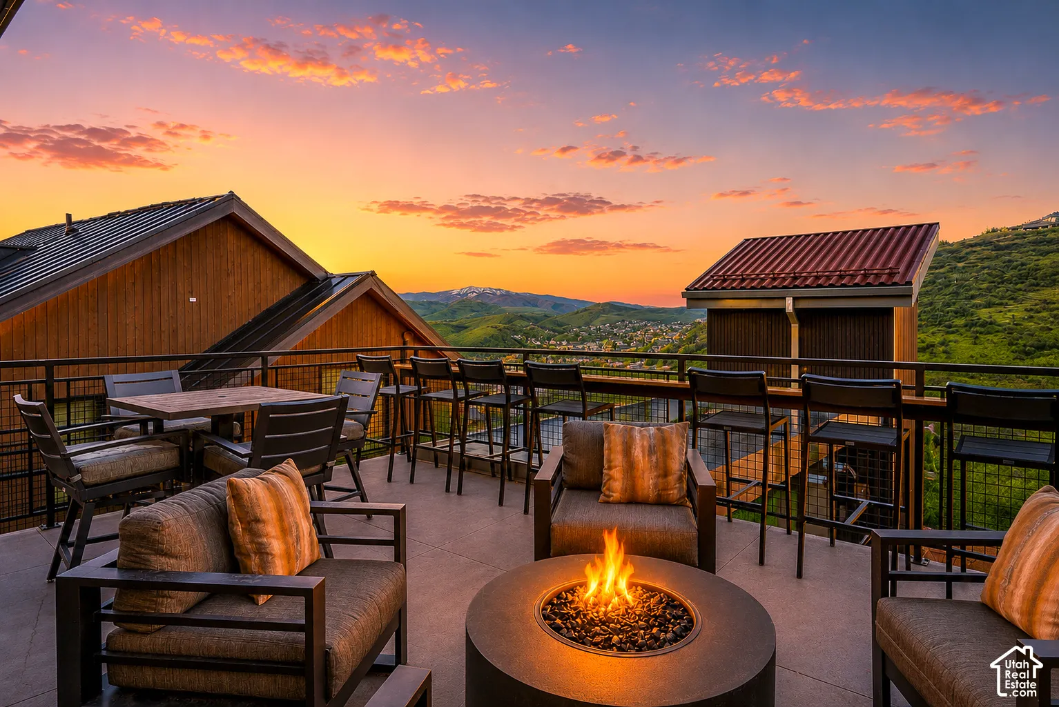 Expansive outdoor patio featuring a built-in fire pit, multiple seating areas, and modern metal railings