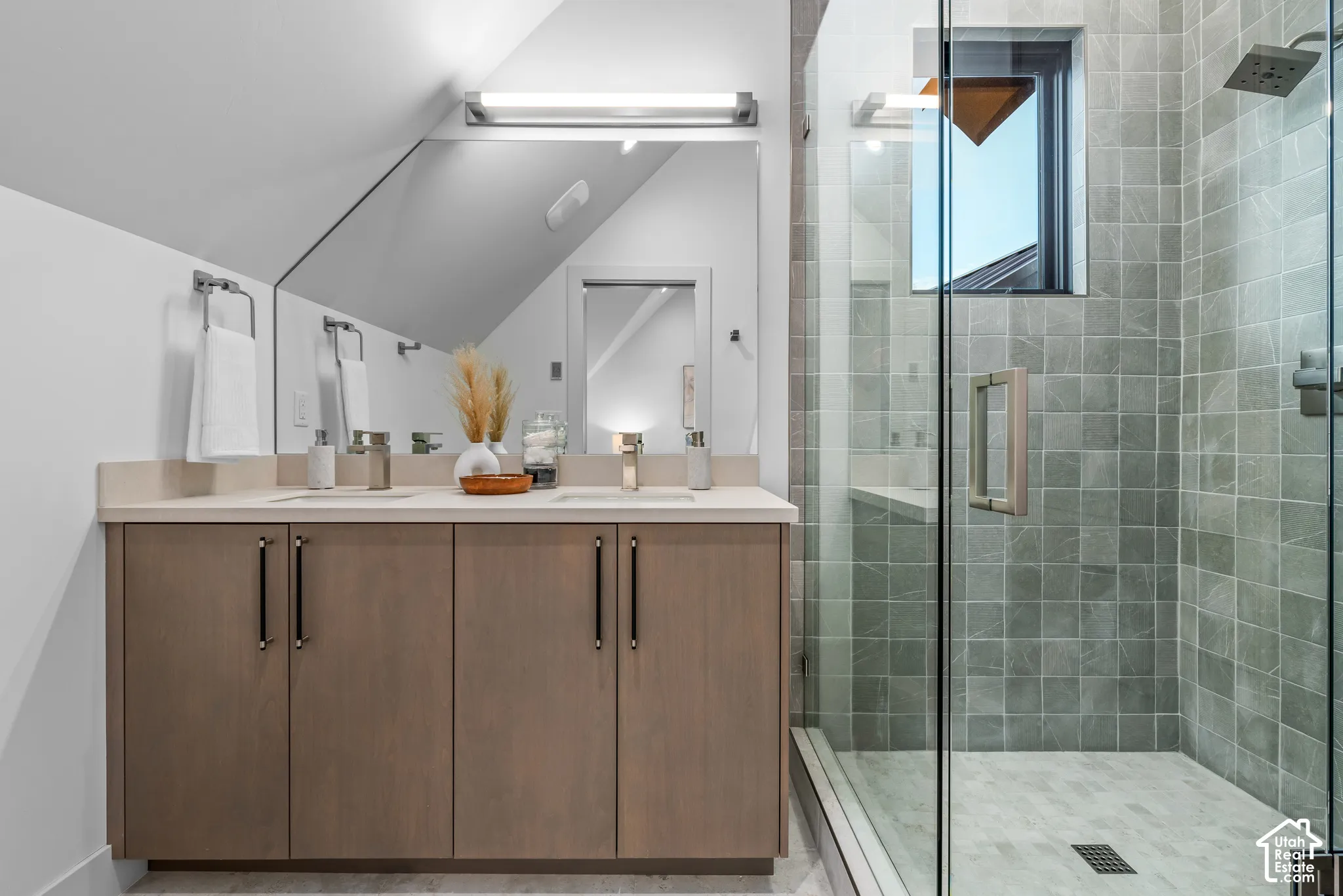 Bathroom featuring a dual-sink vanity with light-toned cabinetry and a light countertop