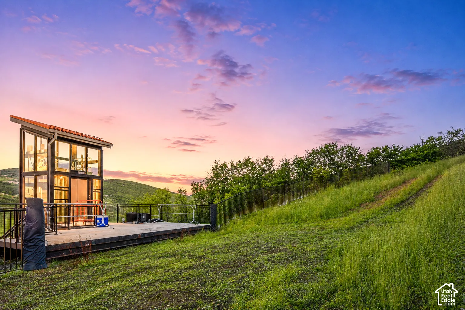 Modern structure featuring extensive glazing, a pitched tile roof, and an expansive outdoor deck