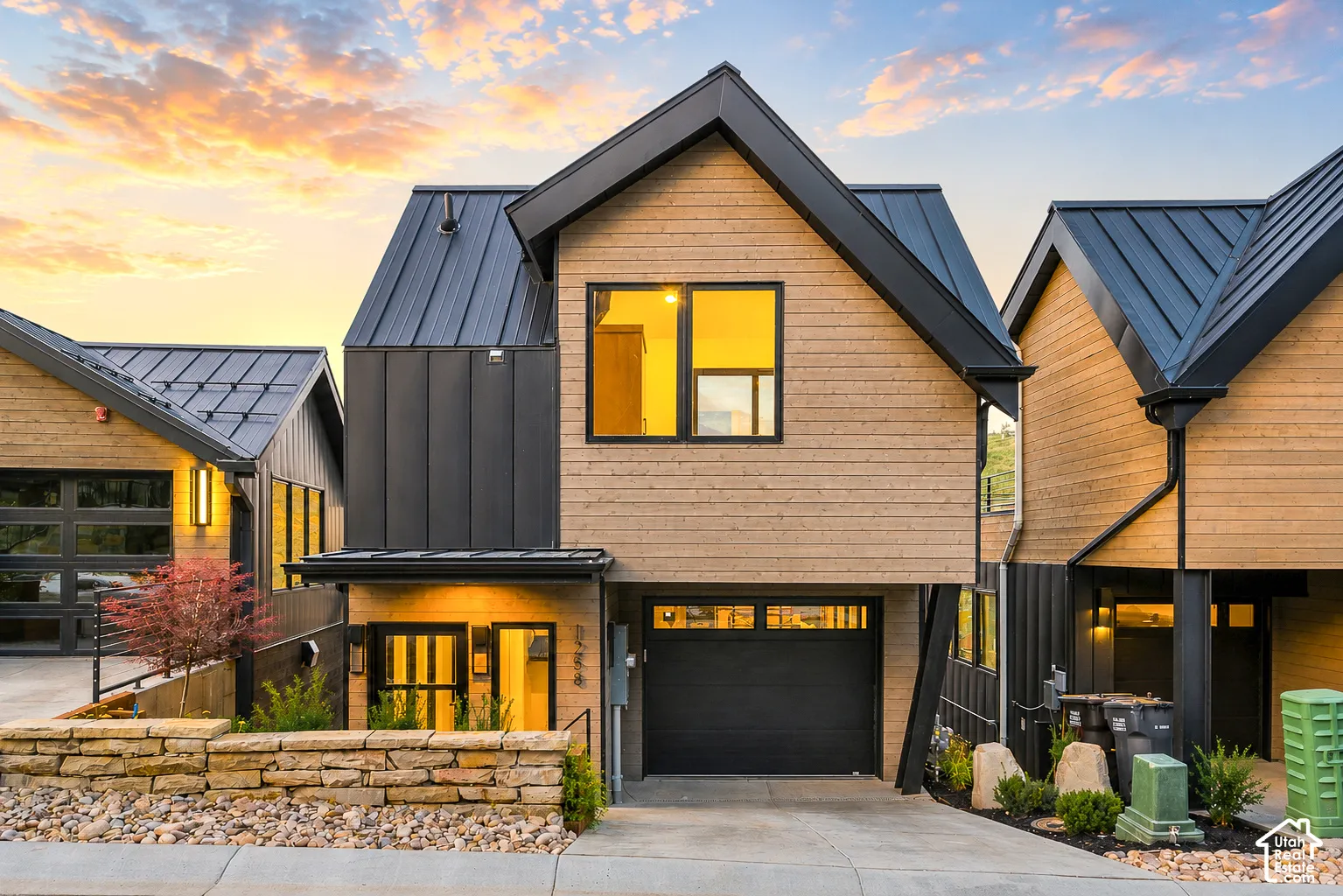Contemporary facade featuring wood-finish siding and black metal roofing
