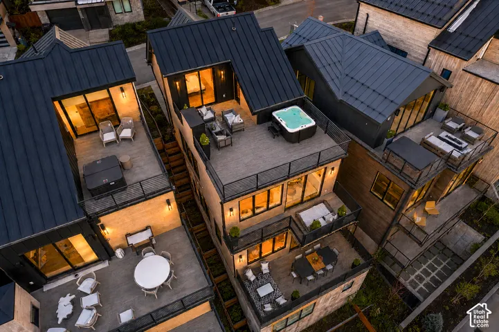 Modern multi-level dwelling with dark metal roofing and multiple outdoor living spaces