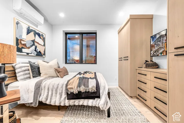 Light-toned wood-finish flooring complements the built-in cabinetry and dresser, featuring black hardware