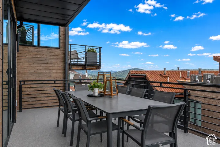 Outdoor terrace featuring a concrete-style floor and black metal railings