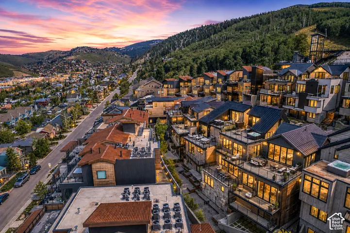 Terraced hillside residences featuring expansive window walls, private balconies, and rooftop hot tubs