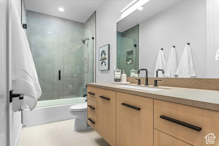 Contemporary bathroom featuring a light wood-finish vanity with a stone-finish countertop and integrated sink